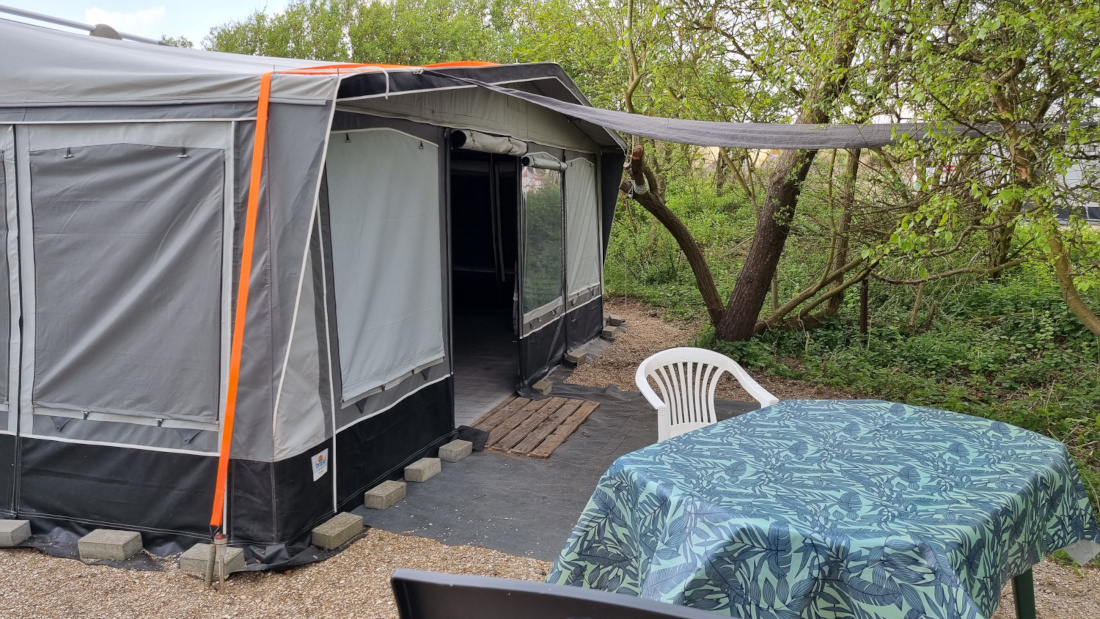 Sitzen Sie sonnengeschützt vor dem Wohnwagen